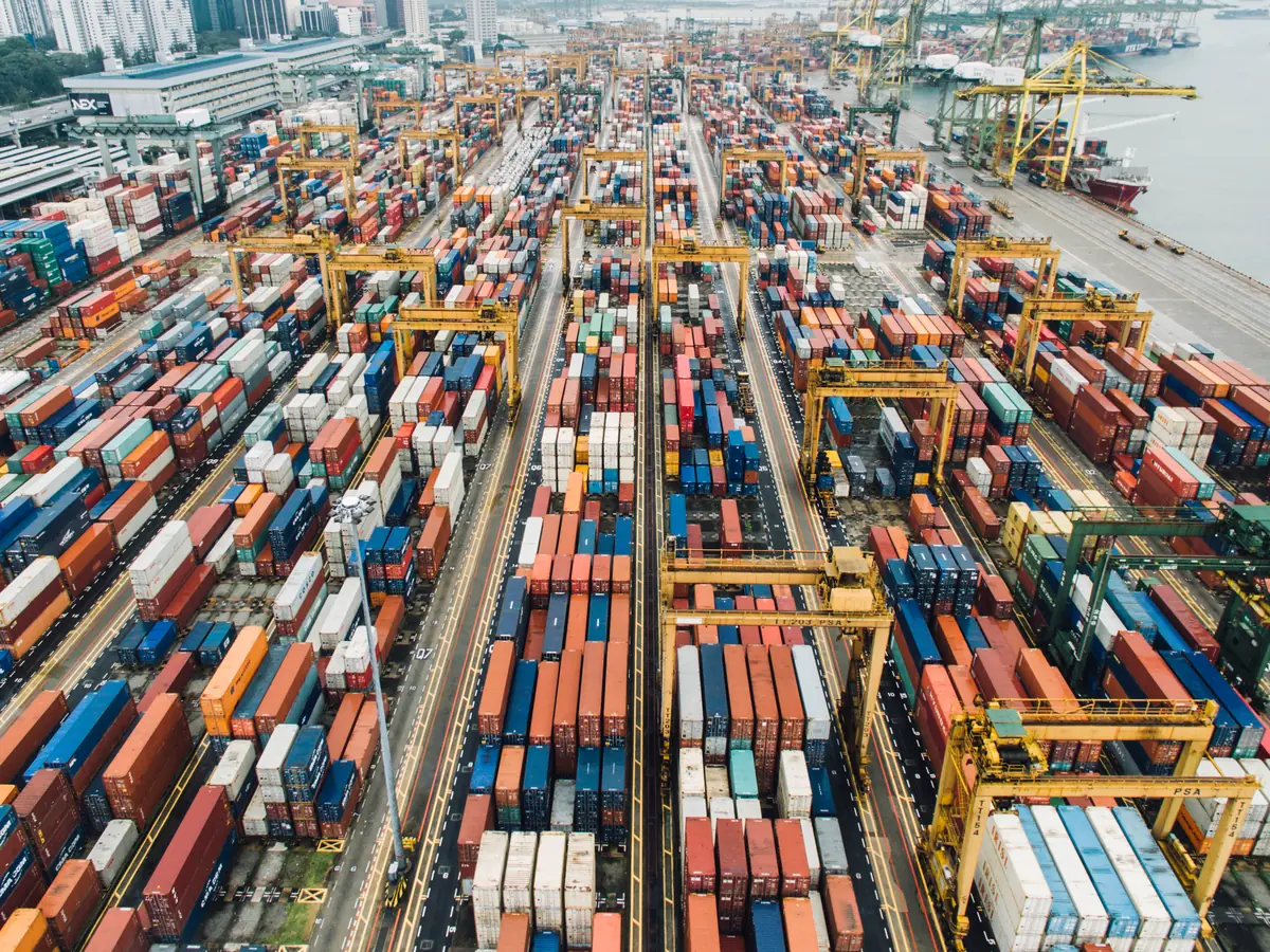 Terminal portuaria con contenedores apilados y grúas de patio